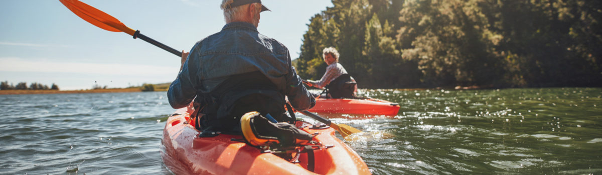 man and woman in orange kayaks